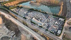 Aerial view of big parking lot of junkyard with rows of discarded broken cars. Recycling of old vehicles