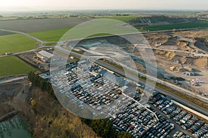 Aerial view of big parking lot of junkyard with rows of discarded broken cars. Recycling of old vehicles