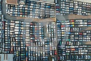 Aerial view of big parking lot of junkyard with rows of discarded broken cars. Recycling of old vehicles