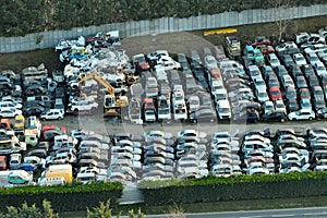 Aerial view of big parking lot of junkyard with rows of discarded broken cars. Recycling of old vehicles