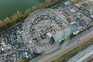 Aerial view of big parking lot of junkyard with rows of discarded broken cars. Recycling of old vehicles