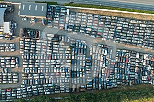 Aerial view of big parking lot of junkyard with rows of discarded broken cars. Recycling of old vehicles