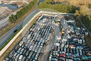 Aerial view of big parking lot of junkyard with rows of discarded broken cars. Recycling of old vehicles