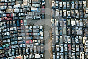 Aerial view of big parking lot of junkyard with rows of discarded broken cars. Recycling of old vehicles