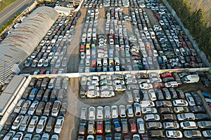 Aerial view of big parking lot of junkyard with rows of discarded broken cars. Recycling of old vehicles