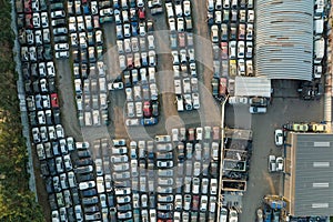 Aerial view of big parking lot of junkyard with rows of discarded broken cars. Recycling of old vehicles