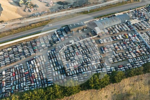 Aerial view of big parking lot of junkyard with rows of discarded broken cars. Recycling of old vehicles