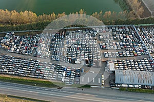 Aerial view of big parking lot of junkyard with rows of discarded broken cars. Recycling of old vehicles