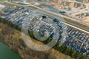 Aerial view of big parking lot of junkyard with rows of discarded broken cars. Recycling of old vehicles