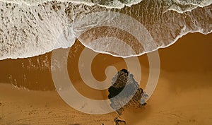 Aerial view of a big sandy beach with waves . Portuguese coastline