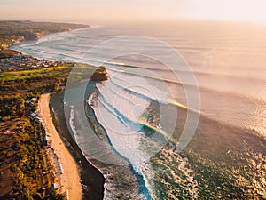 Aerial view of big stormy waves at warm sunset and beach. Biggest ocean wave in Bali