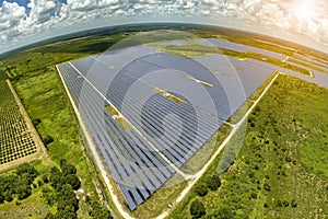 Aerial view of big sustainable electric power plant with many rows of solar photovoltaic panels for producing clean