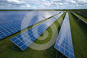 Aerial view of big sustainable electric power plant with many rows of solar photovoltaic panels for producing clean