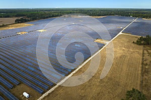 Aerial view of big sustainable electric power plant with many rows of solar photovoltaic panels for producing clean