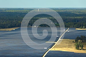 Aerial view of big sustainable electric power plant with many rows of solar photovoltaic panels for producing clean