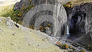 Aerial view of the big waterfall, Caucasus. Powerful stream of clean water escapes from melting glacier, falls from the