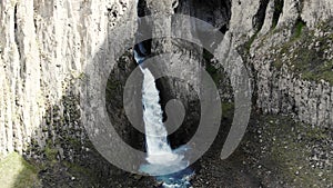 Aerial view of the big waterfall, Caucasus. Powerful stream of clean water runs from the melting glacier, falls down