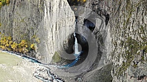 Aerial view of the big waterfall, Caucasus. Powerful stream of clean water runs from the melting glacier, falls down