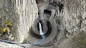 Aerial view of the big waterfall, Caucasus. Powerful stream of clean water runs from the melting glacier, falls down
