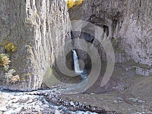 Aerial view of the big waterfall, Caucasus. Powerful stream of clean water runs from the melting glacier, falls down