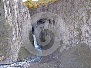 Aerial view of the big waterfall, Caucasus. Powerful stream of clean water runs from the melting glacier, falls down