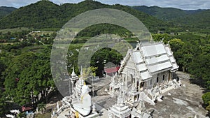 Aerial view of big white Buddha statue in temple. Sumnuk Song Numpu Ron Monastery in Ban Kha, Ratchaburi, Thailand.