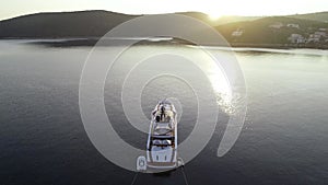 Aerial view of big white luxury yacht embarked in bay or harbour. Beautiful green island during summer season. Sailing experience