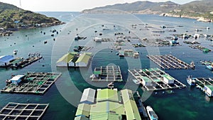 Aerial view of Binh Hung island with tourists, fishing boats, fishing villages and floating rafts raising seafood in Ninh Thuan