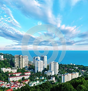 Aerial view of blue coast of Black Sea near  Sochi city with residential houses and recreation area under summer cloudy sky