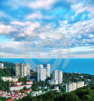 Aerial view of blue coast of Black Sea near  Sochi city with residential houses and recreation area under summer cloudy sky