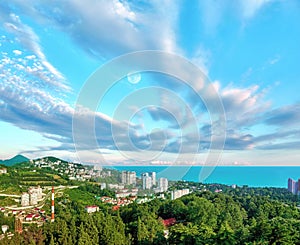 Aerial view of blue coast of Black Sea near  Sochi city with residential houses and recreation area under summer cloudy sky