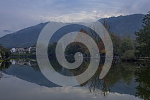 Aerial view of a blue lake and autumn trees on the shore in Hongcun, Anhui, China