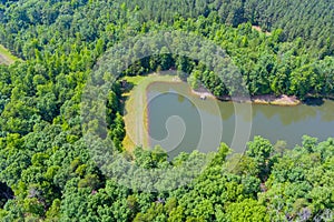 Aerial view of blue lake mountain between green summer forest in Campobello, South Carolina