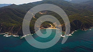 Aerial view of a blue ocean near a cliffy shore at daytime