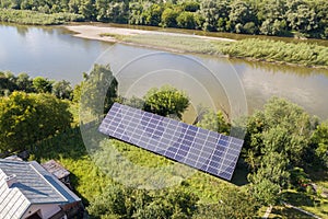 Aerial view of blue photovoltaic solar panels mounted on backyard ground for producing clean ecological electricity