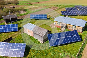 Aerial view of blue photovoltaic solar panels mounted on backyard ground for producing clean ecological electricity. Production of