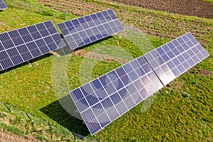Aerial view of blue photovoltaic solar panels mounted on backyard ground for producing clean ecological electricity. Production of photo