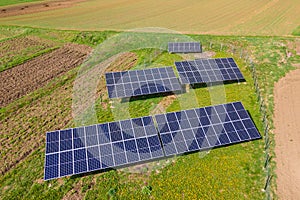 Aerial view of blue photovoltaic solar panels mounted on backyard ground for producing clean ecological electricity. Production of