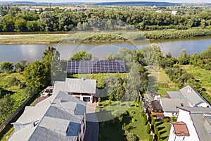 Aerial view of blue photovoltaic solar panels mounted on backyard ground for producing clean ecological electricity. Production of