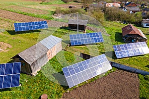 Aerial view of blue photovoltaic solar panels mounted on backyard ground for producing clean ecological electricity. Production of