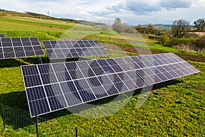 Aerial view of blue photovoltaic solar panels mounted on backyard ground for producing clean ecological electricity. Production of