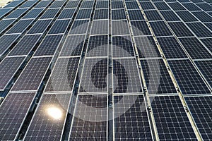 Aerial view of blue photovoltaic solar panels mounted on industrial building roof for producing clean ecological