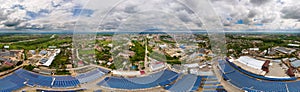 Aerial view of blue photovoltaic solar panels mounted on industrial building roof for producing clean ecological electricity.