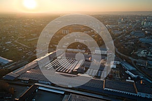 Aerial view of blue photovoltaic solar panels mounted on industrial building roof for producing green ecological