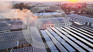 Aerial view of blue photovoltaic solar panels mounted on industrial building roof for producing green ecological