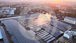 Aerial view of blue photovoltaic solar panels mounted on industrial building roof for producing green ecological