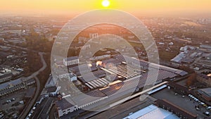 Aerial view of blue photovoltaic solar panels mounted on industrial building roof for producing green ecological