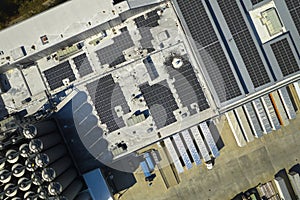 Aerial view of blue photovoltaic solar panels mounted on industrial building roof for producing green ecological