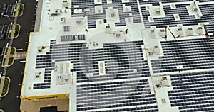 Aerial view of blue photovoltaic solar panels mounted on shopping mall building roof for producing green ecological