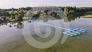 Aerial view of blue plastic pier with fishing boats. Small boats floating on the lake near the pier. Relax concept for design